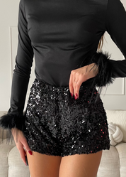 REVES - top nero effetto lucido con polsini in piume