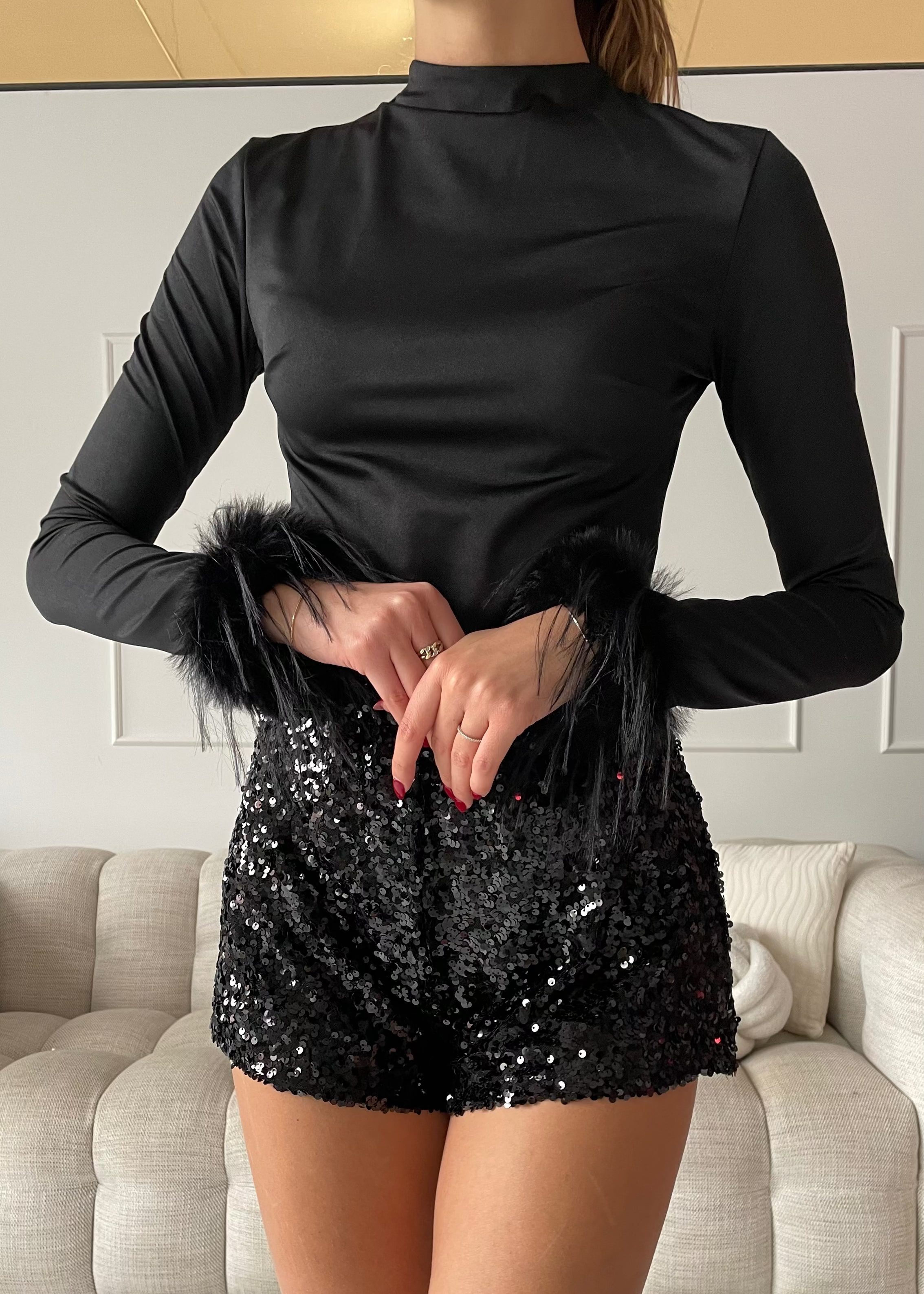 REVES - top nero effetto lucido con polsini in piume